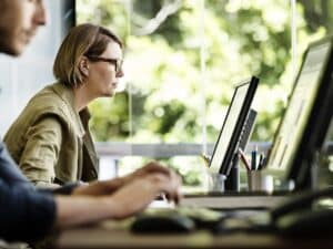 Side view of businesswoman working on computer at desk in office